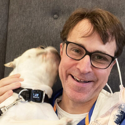 Kevin J. Roberts smiling with a dog.